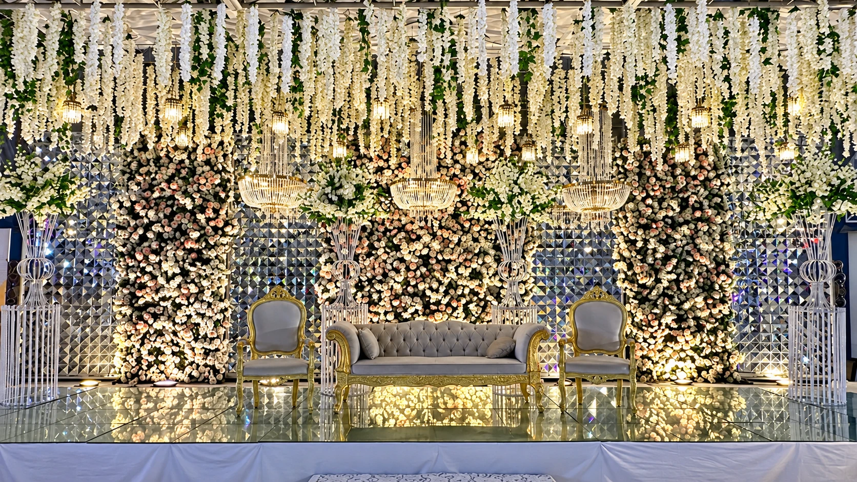 White floral Walima stage with hanging wisteria and crystal chandeliers